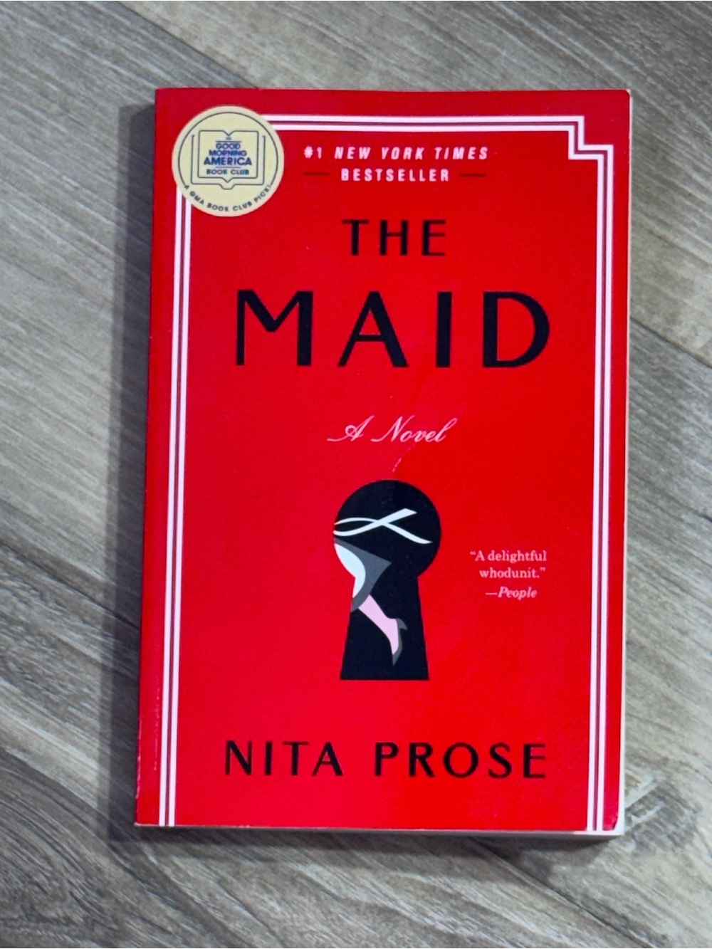 The Maid by Nita Prose - Bright Red Paperback Novel